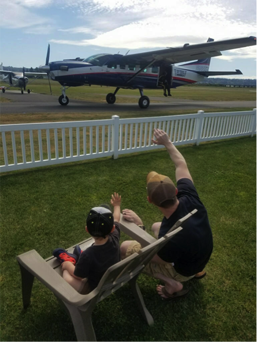 Kids watch planes from the playground at Harvey Field