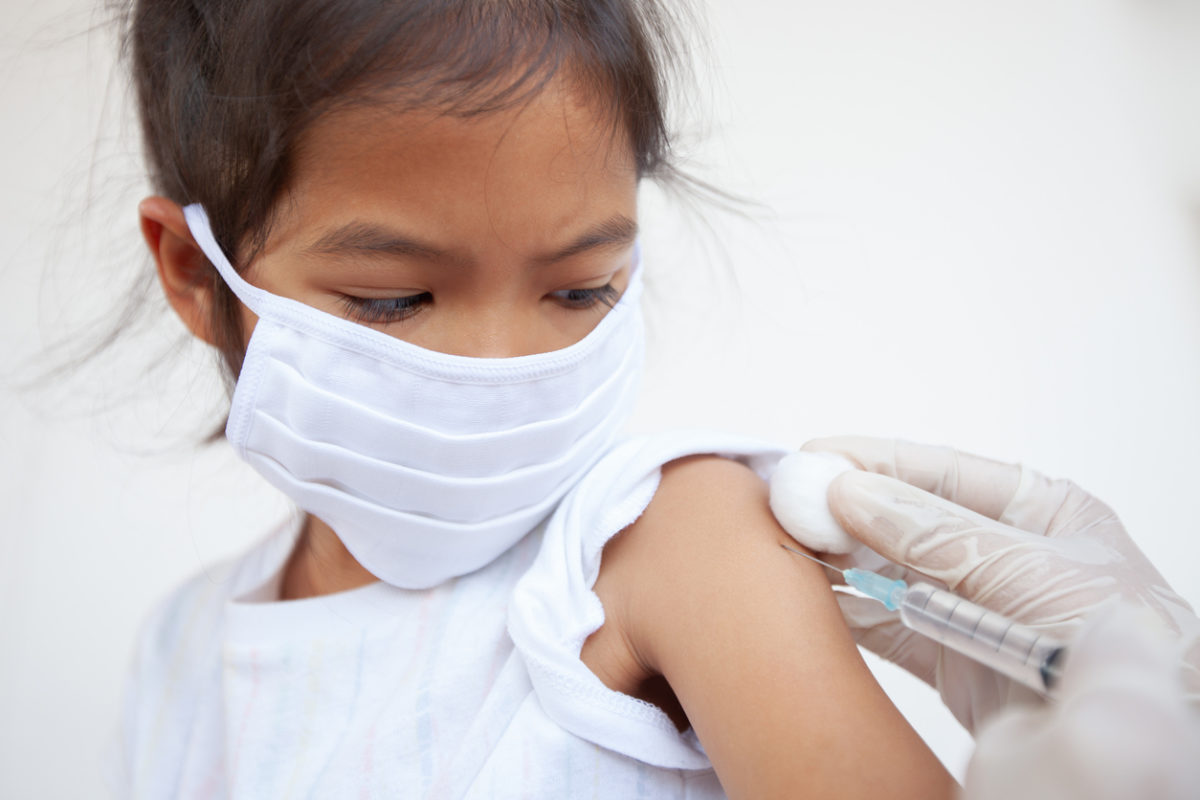 Flu shot: Masked girl getting an injection.