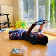 Screen-free days: Child lying on floor reading