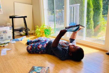 Screen-free days: Child lying on floor reading