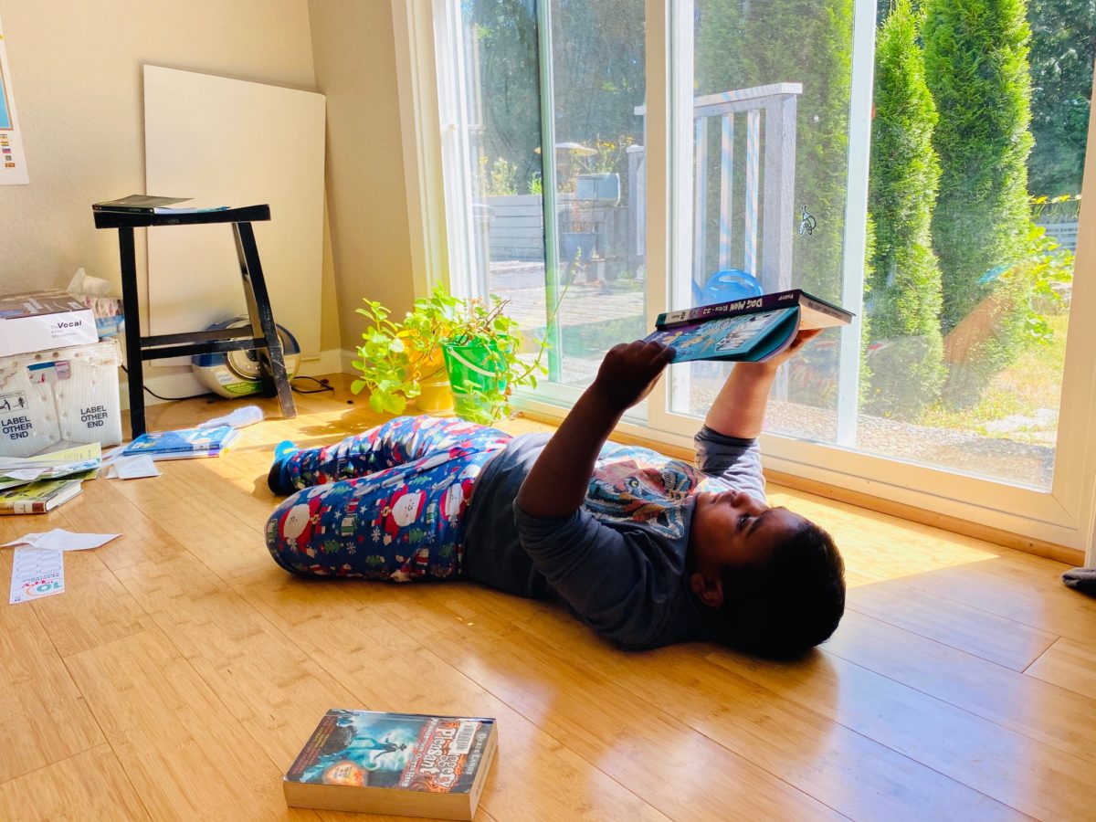 Screen-free days: Child lying on floor reading