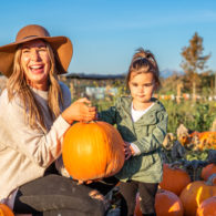 Farm country: woman and child with pumpkin in Stocker Farms pumpkin patch