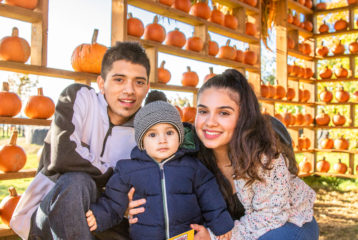 Pumpkin patch: Man, woman and child in front of pumpkins at Stocker Farm