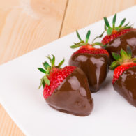 Four chocolate dipped strawberries on a plate