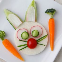 Bunny face on plate made with carrots, cucumbers, radishes, jicama and broccoli