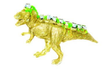 A handmade “Menorasaurus Rex” menorah — a bright, dinosaur-shaped hanukkiyah with candle holes along its back and big, toothy grin — ready for Hanukkah.