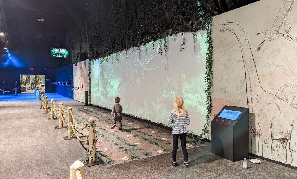 Children race a dinosaur, one of the fun games at Dinos Alive.