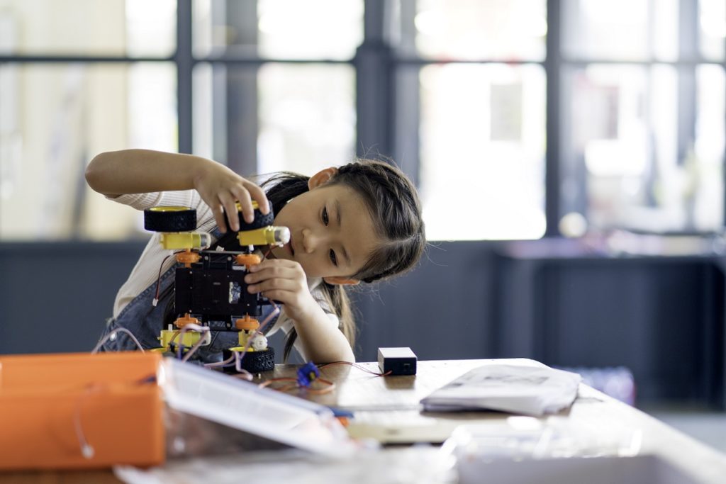 Girl building a robot on a table
