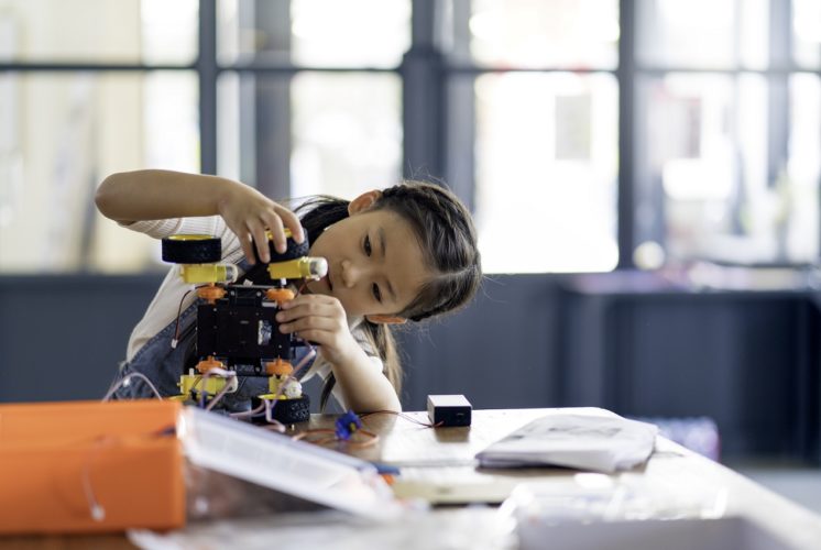 Girl building a robot on a table