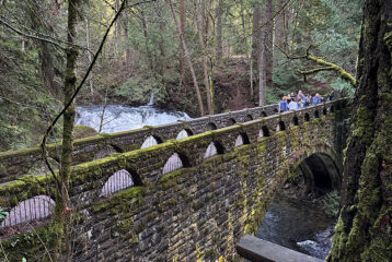 Stone bridge over the creek at Whatcom Falls Park in Bellingham, Washington, with forest views and waterfall access