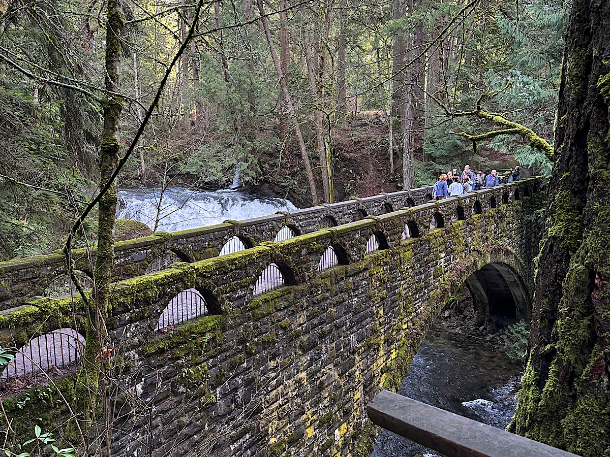 Stone bridge over the creek at Whatcom Falls Park in Bellingham, Washington, with forest views and waterfall access