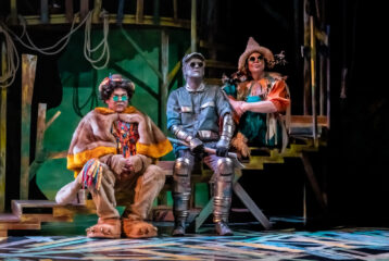 The lion Tin Man and Scarecrow sit with each other on the set of The Wonderful Wizard of Oz