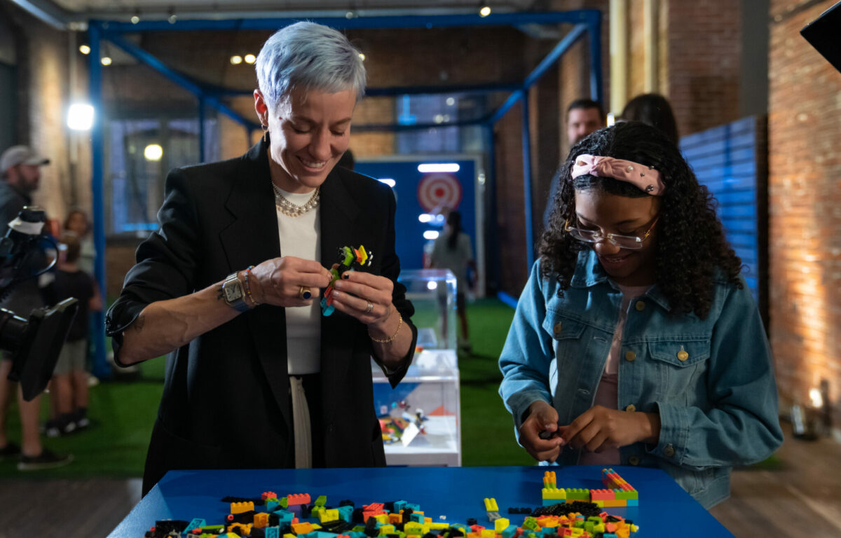 Soccer star Megan Rapinoe, left, and kid reporter Jazlyn 'Jazy' Guerra build LEGO bricks together after the LEGO Group's Play Unstoppable press conference on Friday, June 2, 2023 in Seattle. (Stephen Brashear/AP Images for The LEGO Group)