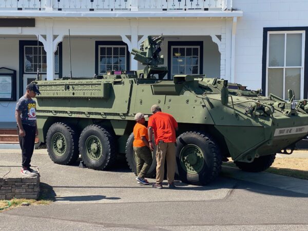 A tank outside of the museum that is green and has 8 wheels