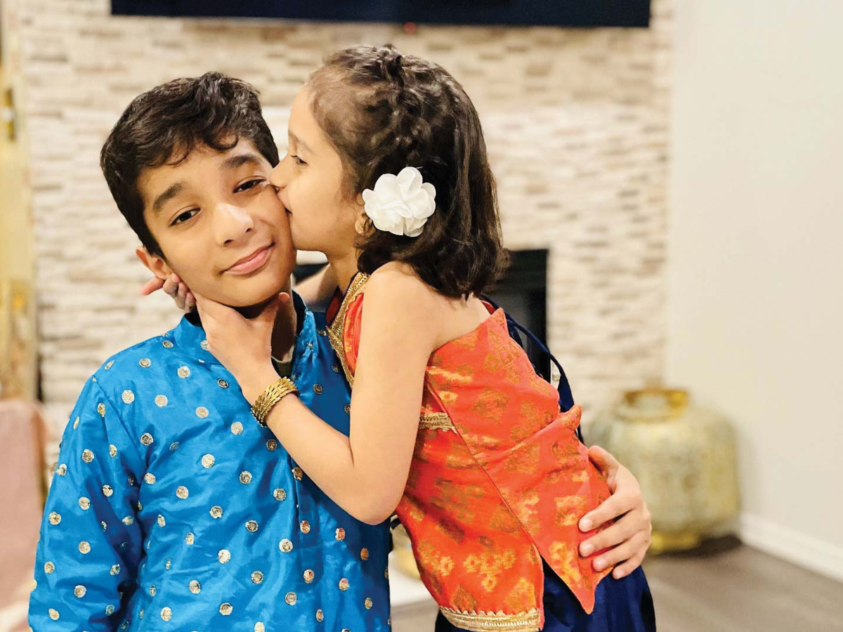 A family decorates their home with glowing diya lamps and marigold garlands for Diwali.
