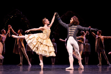 Female dancer holds hands with dancer dressed as a Beast
