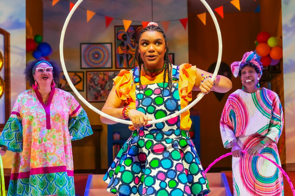Girl holds hula hoop up on stage