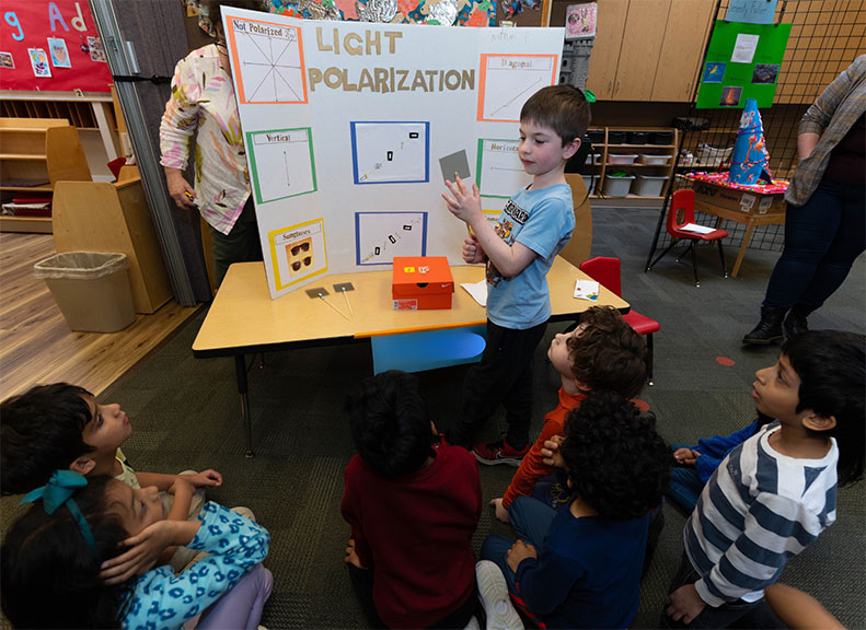 Student presenting science fair demonstration on Light Polarization
