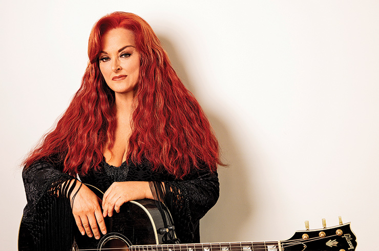 Photo of Evergreen State Fair concert artist Wynonna Judd with a guitar. 
