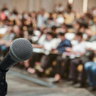 Microphone over the Abstract blurred photo of conference hall or seminar room with attendee background
