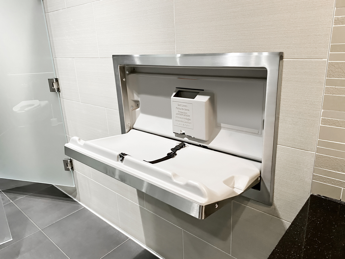 A baby changing station installed in a clean, modern public restroom.
