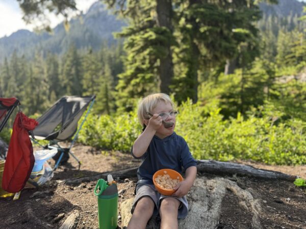 Young child enjoying Annie’s mac and cheese during a backpacking trip
