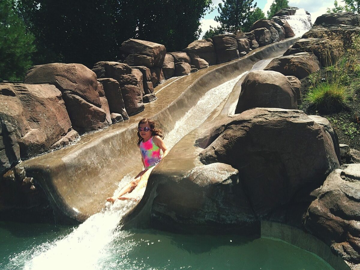 Kid splashing into pool after water slide ride at Sunriver Resort