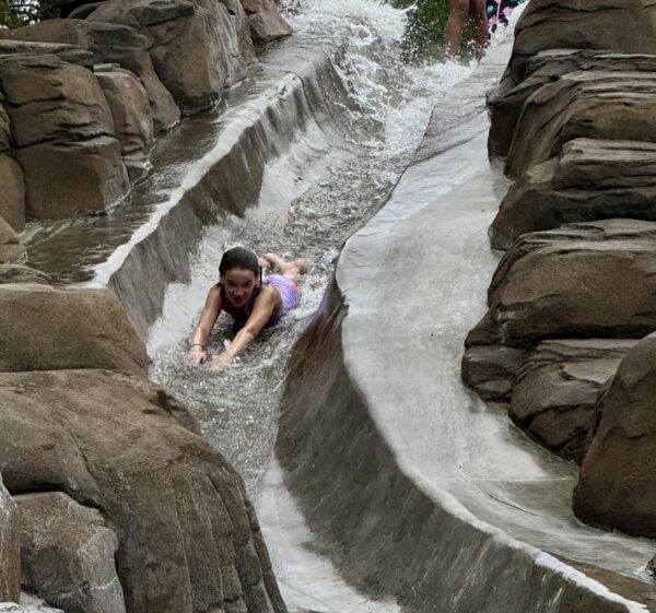 Child riding the rock water slide at The Cove Sunriver Resort
