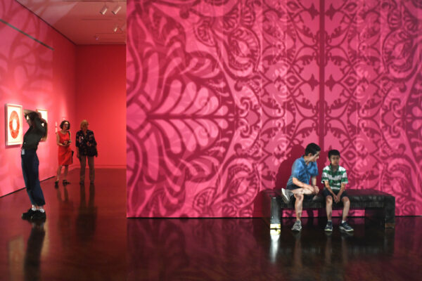 Intricate geometric shadow patterns projected onto gallery walls.