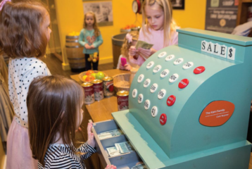A young child builds with blocks in the Construction Zone at KidsQuest Children’s Museum in Bellevue, surrounded by colorful, hands-on exhibits.