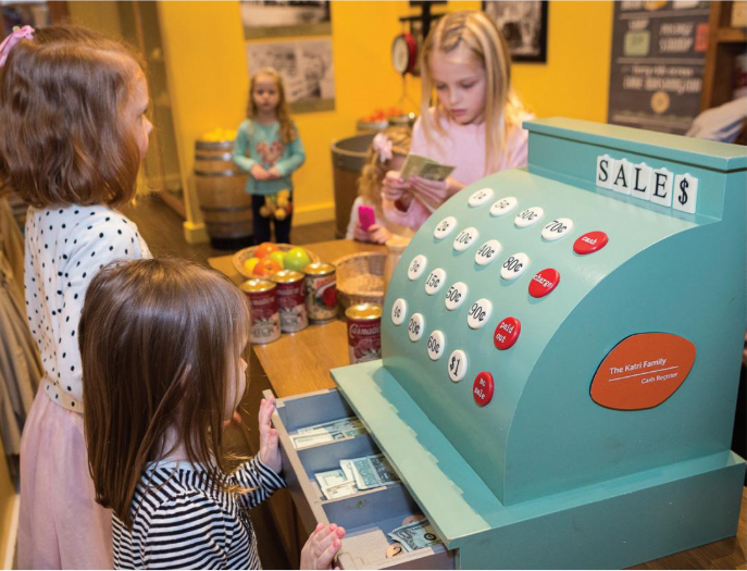 A young child builds with blocks in the Construction Zone at KidsQuest Children’s Museum in Bellevue, surrounded by colorful, hands-on exhibits.