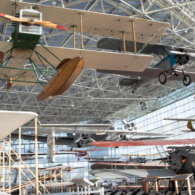 A historic aircraft on display inside the Museum of Flight in Seattle, surrounded by visitors exploring the expansive aviation gallery.