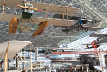 A historic aircraft on display inside the Museum of Flight in Seattle, surrounded by visitors exploring the expansive aviation gallery.