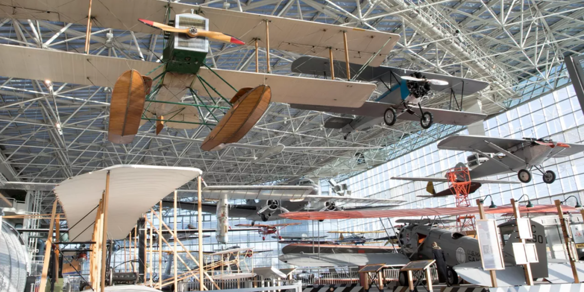 A historic aircraft on display inside the Museum of Flight in Seattle, surrounded by visitors exploring the expansive aviation gallery.