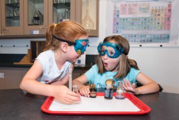 Children observes a hands-on experiment inside the Oregon Museum of Science and Industry (OMSI) in Portland, surrounded by interactive science exhibits.