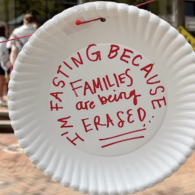 A paper plate with handwritten words: “I’m fasting because families are being erased.”