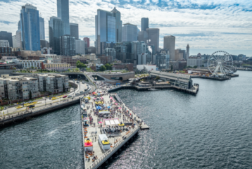 Aerial view of Seattle’s new 20-acre Waterfront Park filled with families enjoying the sunny grand opening celebration.