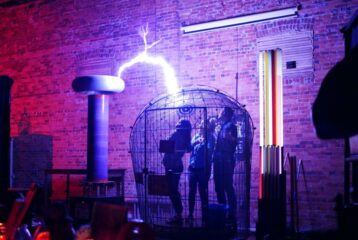 A live coil demonstration inside the SPARK Museum of Electrical Invention in Bellingham, surrounded by glowing electrical displays.