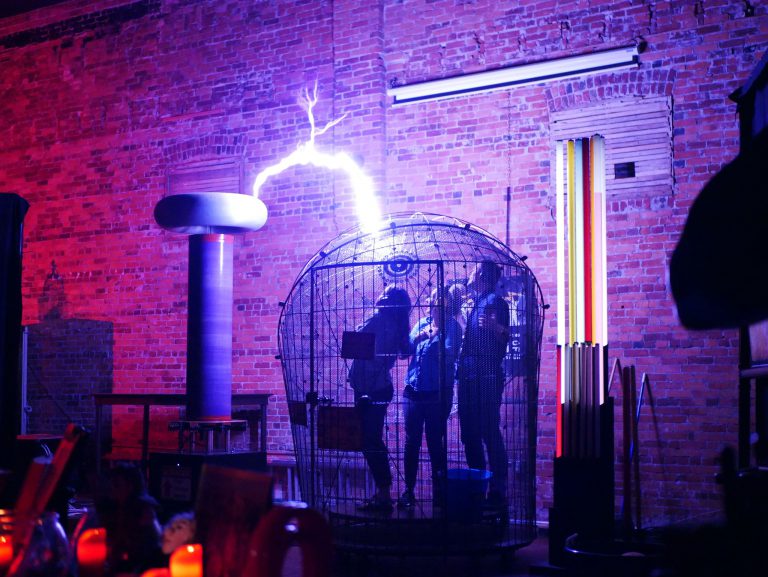 A live coil demonstration inside the SPARK Museum of Electrical Invention in Bellingham, surrounded by glowing electrical displays.
