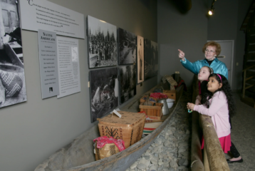 Children look at a historic caboose at the White River Valley Museum in Auburn, surrounded by interactive exhibits that bring local history to life.
