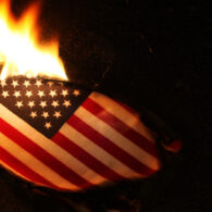 An American flag set on fire during a protest, symbolizing dissent and debate over free speech rights.