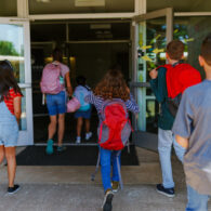 Elementary age students arriving at school