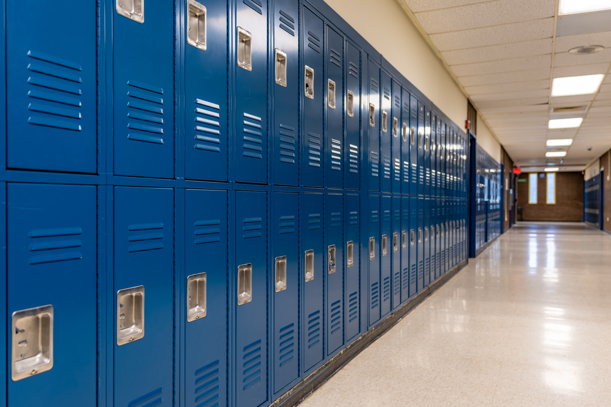 A row of closed lockers in a school hallway, symbolizing the education system