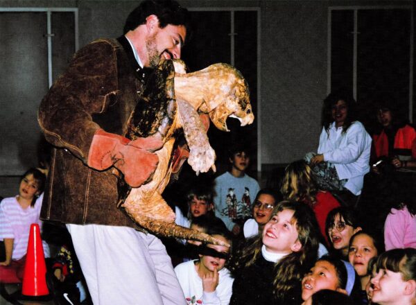 Scott Petersen, known as The Reptile Man, holds a snapping turtle for schoolchildren.