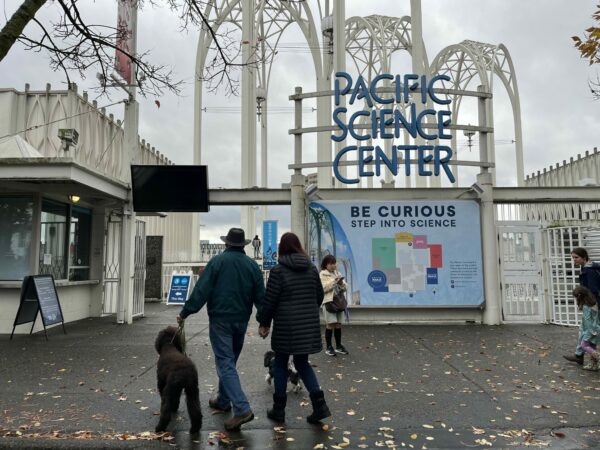 View of the Pacific Science Center courtyard with newly opened gates, showing families walking through the public space.