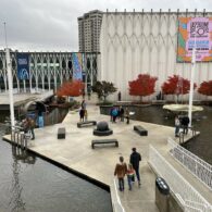 View of the Pacific Science Center courtyard with newly opened gates, showing families walking through the public space.