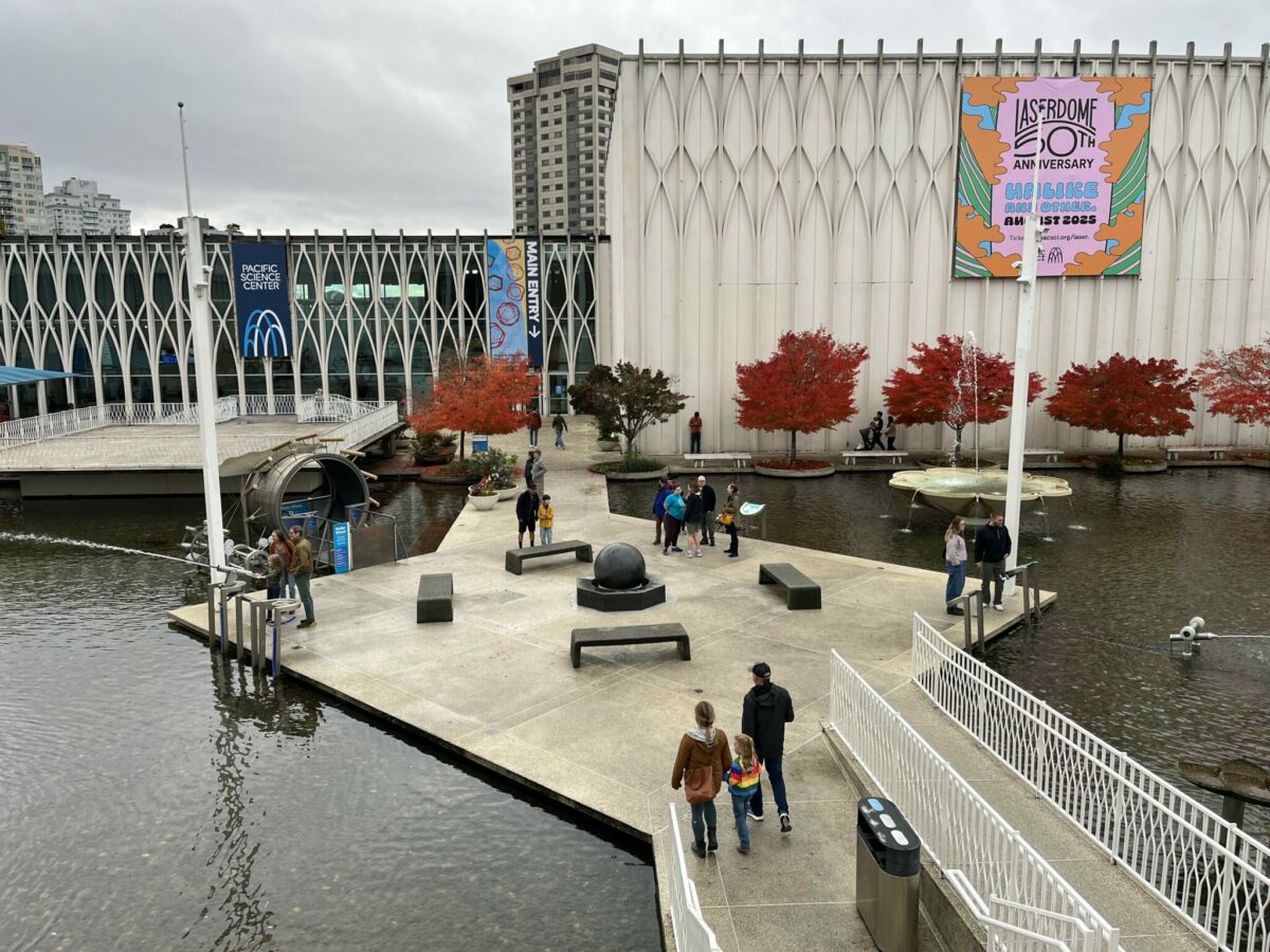 View of the Pacific Science Center courtyard with newly opened gates, showing families walking through the public space.