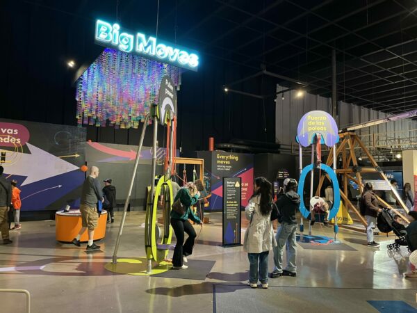 Wide view of the “Spiders: From Fear to Fascination” exhibit at Pacific Science Center, showing displays, interactive elements, and families exploring the gallery.
