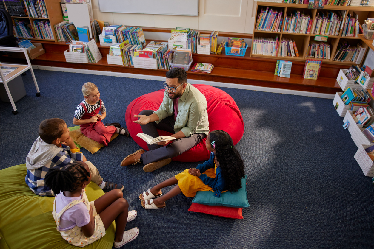 Adult leading a story time at a Seattle library, seated on the floor with young children gathered around and listening